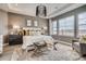 Main bedroom with a large window, tray ceiling, neutral color palette, and a cozy sitting area at 3884 Freestone Pt, Castle Rock, CO 80108