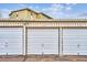 Three-car garage with white roll-up doors at 635 S Alton Way # 1C, Denver, CO 80247