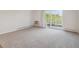 Carpeted living room with sliding door leading to a balcony and exterior view at 635 S Alton Way # 1C, Denver, CO 80247