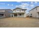 Backyard view of the two-story home with a patio, tan and gray siding, and white columns at 1362 Rock Cliff Ave, Erie, CO 80516