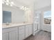 Bathroom boasts double sinks, a large mirror, a glass door shower, and wood flooring at 1362 Rock Cliff Ave, Erie, CO 80516