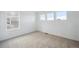 Bedroom with three windows providing natural light and neutral colored carpeting at 1362 Rock Cliff Ave, Erie, CO 80516