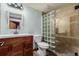 This bathroom is complete with glass block shower, ceramic tile, and wood vanity at 1341 Tomichi Dr, Franktown, CO 80116
