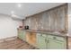 Finished basement kitchenette offers stainless sink, green cabinets, concrete counters, and vintage corrugated tin wall at 1341 Tomichi Dr, Franktown, CO 80116