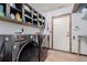 Laundry room features black washer and dryer and shelving at 1341 Tomichi Dr, Franktown, CO 80116