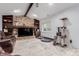 Cozy living room with a stone fireplace, built-in shelves, and beamed ceiling at 1341 Tomichi Dr, Franktown, CO 80116