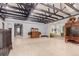 Open living room with light wood floors, staircase, and exposed beam vaulted ceiling at 1341 Tomichi Dr, Franktown, CO 80116