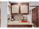 A wet bar with a mosaic tile backsplash, wooden cabinets, and a small sink at 1341 Tomichi Dr, Franktown, CO 80116