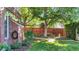 Inviting backyard featuring a lush lawn, mature trees, and a classic brick building with a hose at 926 S Fillmore Way, Denver, CO 80209