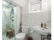 Bright bathroom featuring a glass shower, a modern toilet, and an elegant sink with stylish fixtures at 926 S Fillmore Way, Denver, CO 80209