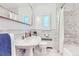 Beautiful bathroom with marble walls, a pedestal sink, and classic fixtures at 926 S Fillmore Way, Denver, CO 80209