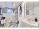 Cozy bathroom featuring a black and white tiled floor, beadboard walls, and a pedestal sink at 926 S Fillmore Way, Denver, CO 80209