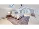 Stylish bedroom featuring skylights, a large arched window, and a plush rug at 926 S Fillmore Way, Denver, CO 80209