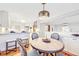 Bright dining room featuring a round table with gray upholstered chairs, and open access to the modern kitchen at 926 S Fillmore Way, Denver, CO 80209