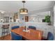 Open dining area with wood table, blue chairs, and seamless flow to kitchen at 926 S Fillmore Way, Denver, CO 80209