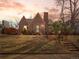 Charming brick home with mature landscaping, stone stairs, and a neatly manicured lawn at sunset at 926 S Fillmore Way, Denver, CO 80209