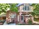 Charming brick home featuring an arched window, a small front patio with seating, and landscaped front yard at 926 S Fillmore Way, Denver, CO 80209