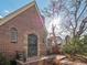 Charming brick home featuring an arched window, a small front patio with seating, and landscaped front yard at 926 S Fillmore Way, Denver, CO 80209