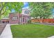 Charming brick home with a lush green lawn, mature trees, and well-maintained landscaping at 926 S Fillmore Way, Denver, CO 80209