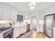 Bright kitchen features white cabinets, stainless steel appliances, ample counter space, and hardwood floors at 926 S Fillmore Way, Denver, CO 80209