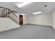 Bright basement area with gray carpeting, stairs, and white walls offer space for storage and recreation at 3061 W 92Nd Ave # 8B, Westminster, CO 80031