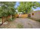 View of a private, gravel backyard featuring a wood fence and mature trees at 194 S Emerson St, Denver, CO 80209