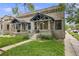 Charming stone-clad home with covered front porch and manicured lawn offers great curb appeal at 194 S Emerson St, Denver, CO 80209