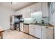 Bright kitchen features stainless steel appliances, white cabinets, and stylish tile backsplash at 194 S Emerson St, Denver, CO 80209