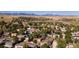 Aerial view of a residential area showcasing well-maintained homes, mature trees, and distant mountain views at 10640 Nw Routt Way, Westminster, CO 80021