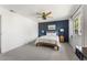 Stylish bedroom featuring a navy accent wall, plush carpet, and a comfortable queen-sized bed at 10640 Nw Routt Way, Westminster, CO 80021