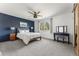 Stylish bedroom featuring a navy accent wall, plush carpet, and a comfortable queen-sized bed at 10640 Nw Routt Way, Westminster, CO 80021
