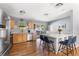 Open-concept kitchen featuring stainless steel appliances, white island with seating, and hardwood floors at 10640 Nw Routt Way, Westminster, CO 80021