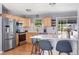 Bright kitchen with stainless steel appliances, light wood cabinets, quartz countertops, and breakfast bar seating at 10640 Nw Routt Way, Westminster, CO 80021