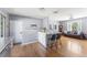 Bright and airy living room with hardwood floors, a modern gray sofa, and a breakfast bar with seating at 10640 Nw Routt Way, Westminster, CO 80021