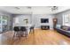 Bright and airy living room with hardwood floors, a modern gray sofa, and a breakfast bar with seating at 10640 Nw Routt Way, Westminster, CO 80021