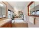 Bright bathroom featuring a soaking tub, double vanity, and large mirror at 20401 High Pines Dr, Monument, CO 80132