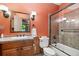 Bathroom featuring a tiled shower-tub, sink, and wood-paneled wall accent with mirror at 20401 High Pines Dr, Monument, CO 80132