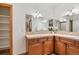Bathroom boasts dual sinks with tile countertops and a large framed mirror at 20401 High Pines Dr, Monument, CO 80132