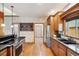 Well-lit kitchen with hardwood floors, granite countertops, stainless steel appliances and built-in shelving for greenery at 20401 High Pines Dr, Monument, CO 80132
