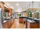 Open kitchen featuring an island with a cooktop, hardwood floors, modern appliances, and an adjacent dining area at 20401 High Pines Dr, Monument, CO 80132