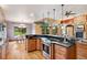 Open kitchen featuring an island with a cooktop, hardwood floors, and access to the dining room and living room at 20401 High Pines Dr, Monument, CO 80132