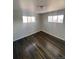 Inviting bedroom with dark laminate flooring, two bright windows, and baseboard heaters at 10866 Pearl St, Northglenn, CO 80233