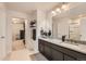 Bright bathroom featuring a double vanity, granite countertops, and tiled shower at 25128 E Maple Ave, Aurora, CO 80018