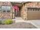 Charming home exterior featuring stone accents, a well-manicured yard, and a two-car garage at 25128 E Maple Ave, Aurora, CO 80018