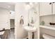 Compact half bathroom with a pedestal sink, oval mirror, and built-in shelving at 25128 E Maple Ave, Aurora, CO 80018