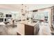 Open-concept kitchen featuring a large island, modern lighting, and view of the living room and dining area at 25128 E Maple Ave, Aurora, CO 80018