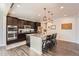 Modern kitchen with dark cabinets, stainless steel appliances, and a large center island with seating at 25128 E Maple Ave, Aurora, CO 80018