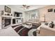 Cozy living room features a fireplace, ceiling fan, stylish rug, and comfortable seating at 25128 E Maple Ave, Aurora, CO 80018