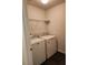 Convenient laundry room with modern washer and dryer units and shelving at 1211 Bistre St, Longmont, CO 80501
