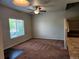Bright living room with a ceiling fan, plush carpet, and large window for natural light at 1211 Bistre St, Longmont, CO 80501